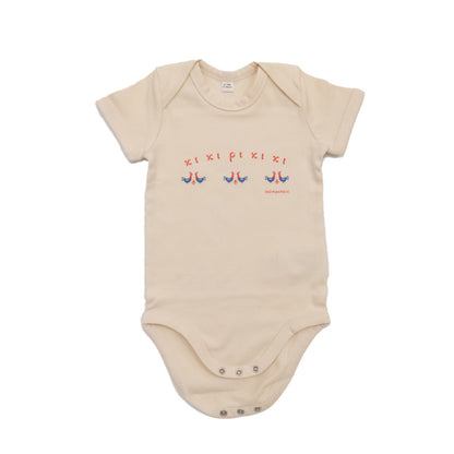 A short-sleeved beige baby bodysuit made of 100% organic cotton. On the front is a repeating design of red and blue roosters with the Greek words "κι κι ρι κι κι" above them.