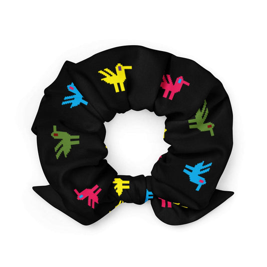 Ducks Recycled Scrunchie, a black scrunchie made of recycled materials with bright yellow, pink, blue, and green ducks printed on it.