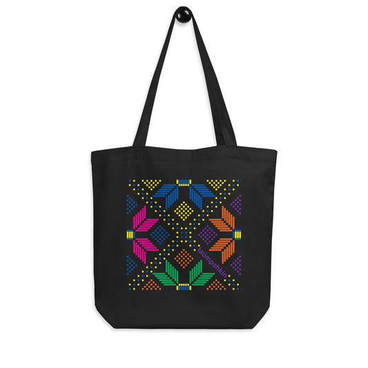 A 100% organic cotton black eco reusable shopping tote bag with a colorful pixelated design of flowers and dots.