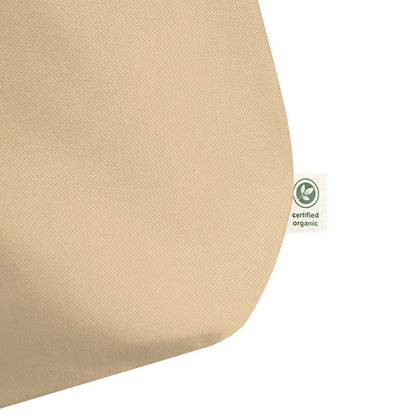 Detail of a small tag on the outer corner of a beige tote bag. It says "certified organic".