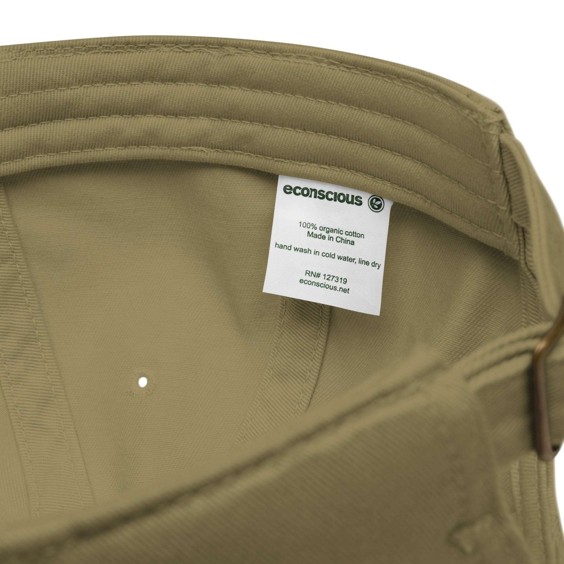 The tag inside a khaki green baseball cap made of 100% organic cotton. It shows the brand, econscious, that it is 100% organic cotton made in China, and the care instructions--hand wash in cold water, line dry.