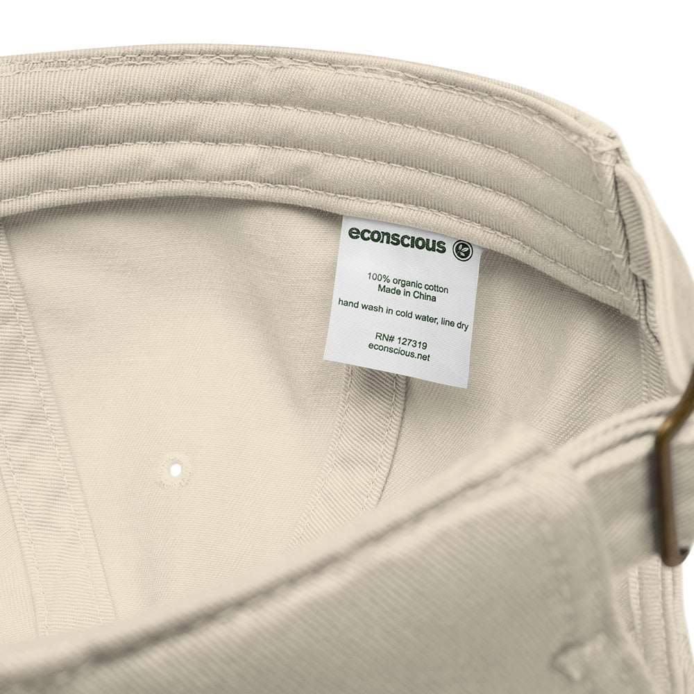 Detail of the tag on a light tan baseball cap showing the brand, Econscious, and that it is made of 100% organic cotton.