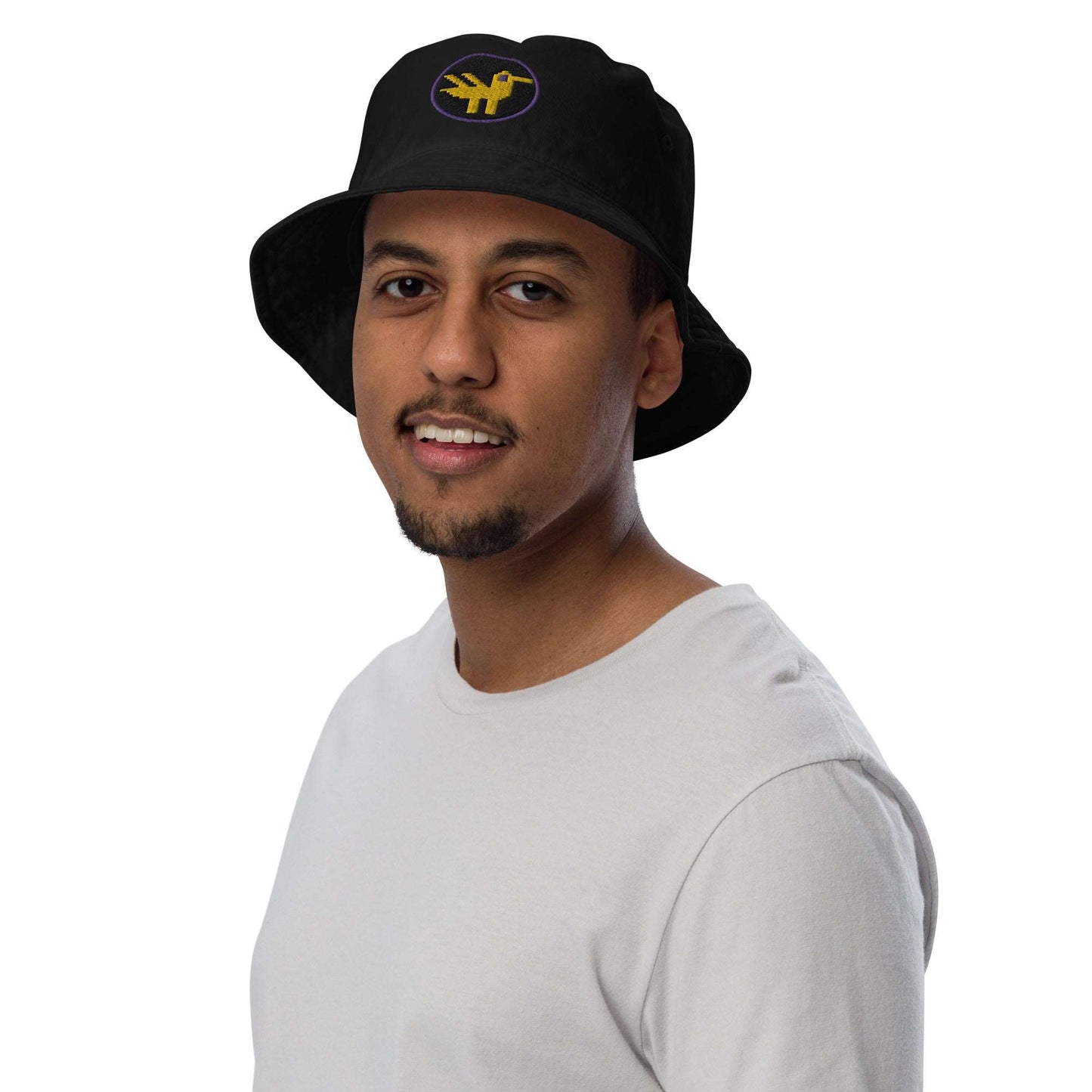 Duck Organic Bucket Hat. A man wearing a black bucket hat made of 100% organic cotton with a large yellow duck with purple details embroidered on the front.