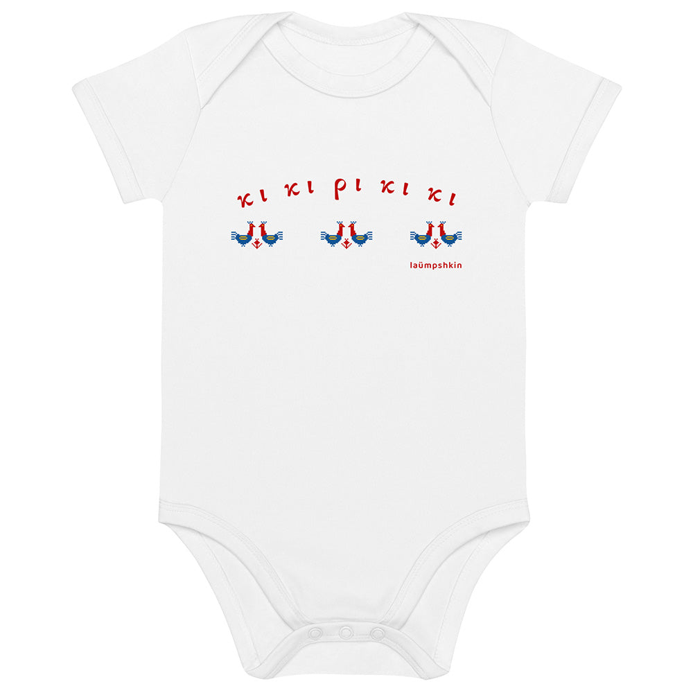 A short-sleeved white baby bodysuit made of 100% organic cotton. On the front is a repeating design of red and blue roosters with the Greek words "κι κι ρι κι κι" above them.