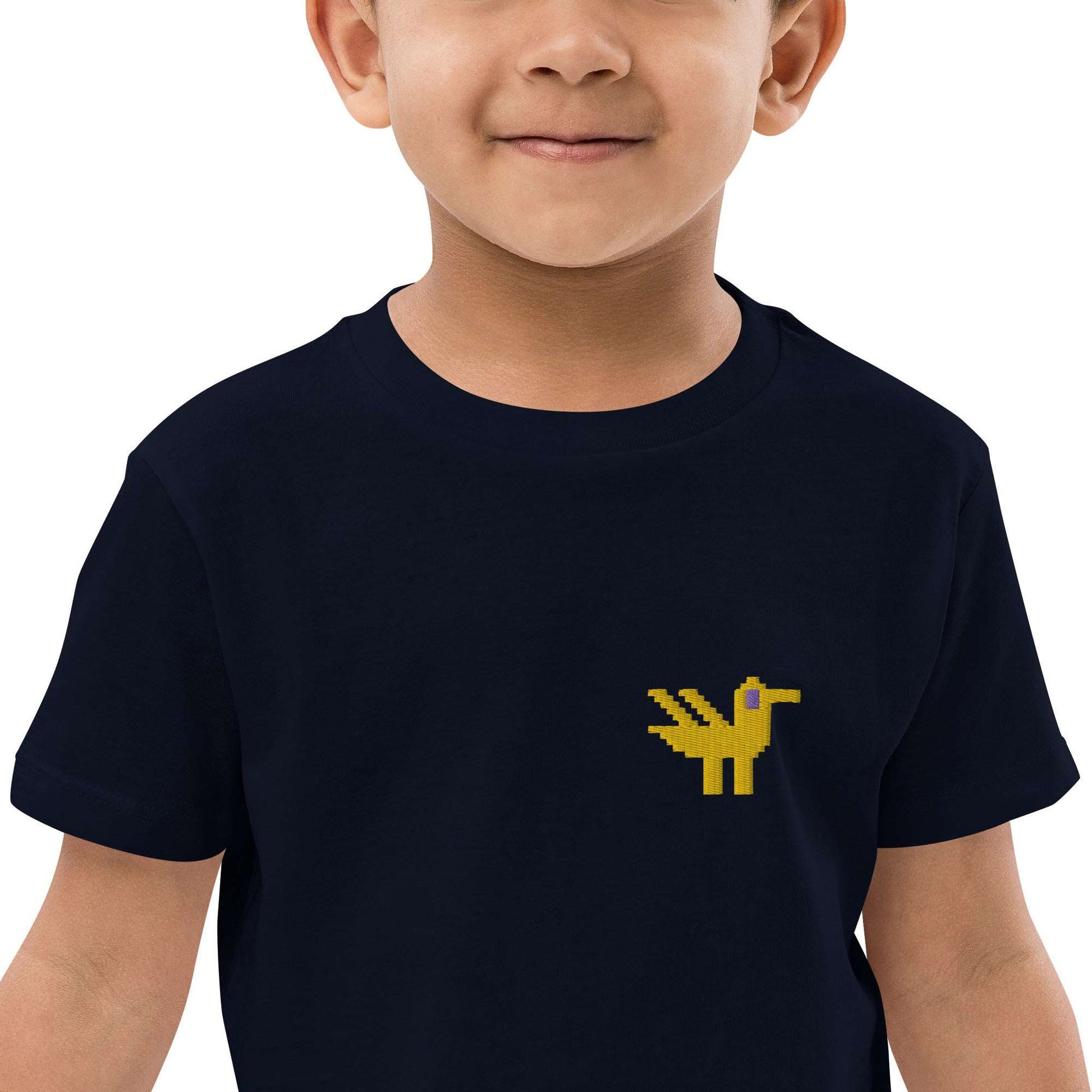 A close-up of a boy wearing a dark navy kids t-shirt made of 100% organic cotton with a yellow duck embroidered on the top left.