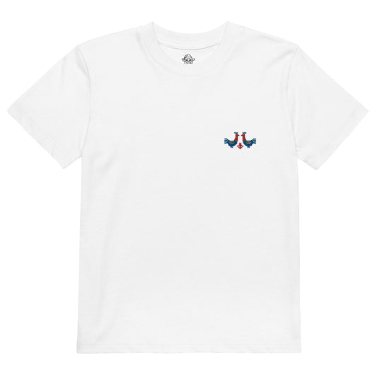 A white t-shirt made of 100% organic cotton with a pair of red and blue roosters embroidered on the top left.