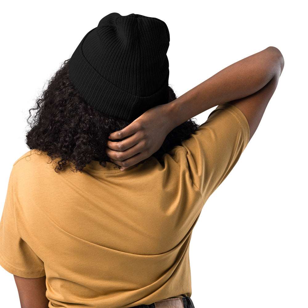 The back of a woman wearing a ribbed black beanie made of 100% organic cotton..