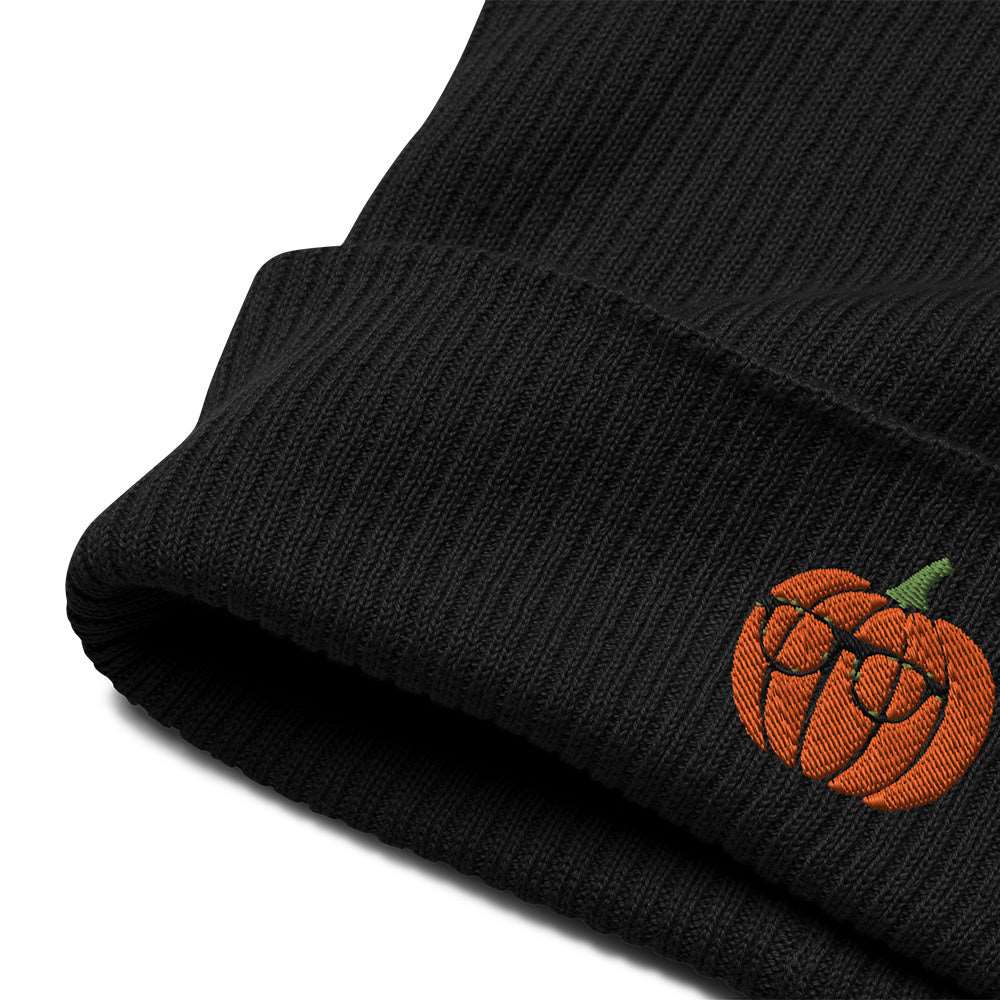 A close-up of the embroidery and cuff on a spooky Halloween ribbed black beanie made of 100% organic cotton with a pumpkin embroidered on the front. The pumpkin is wearing glasses.