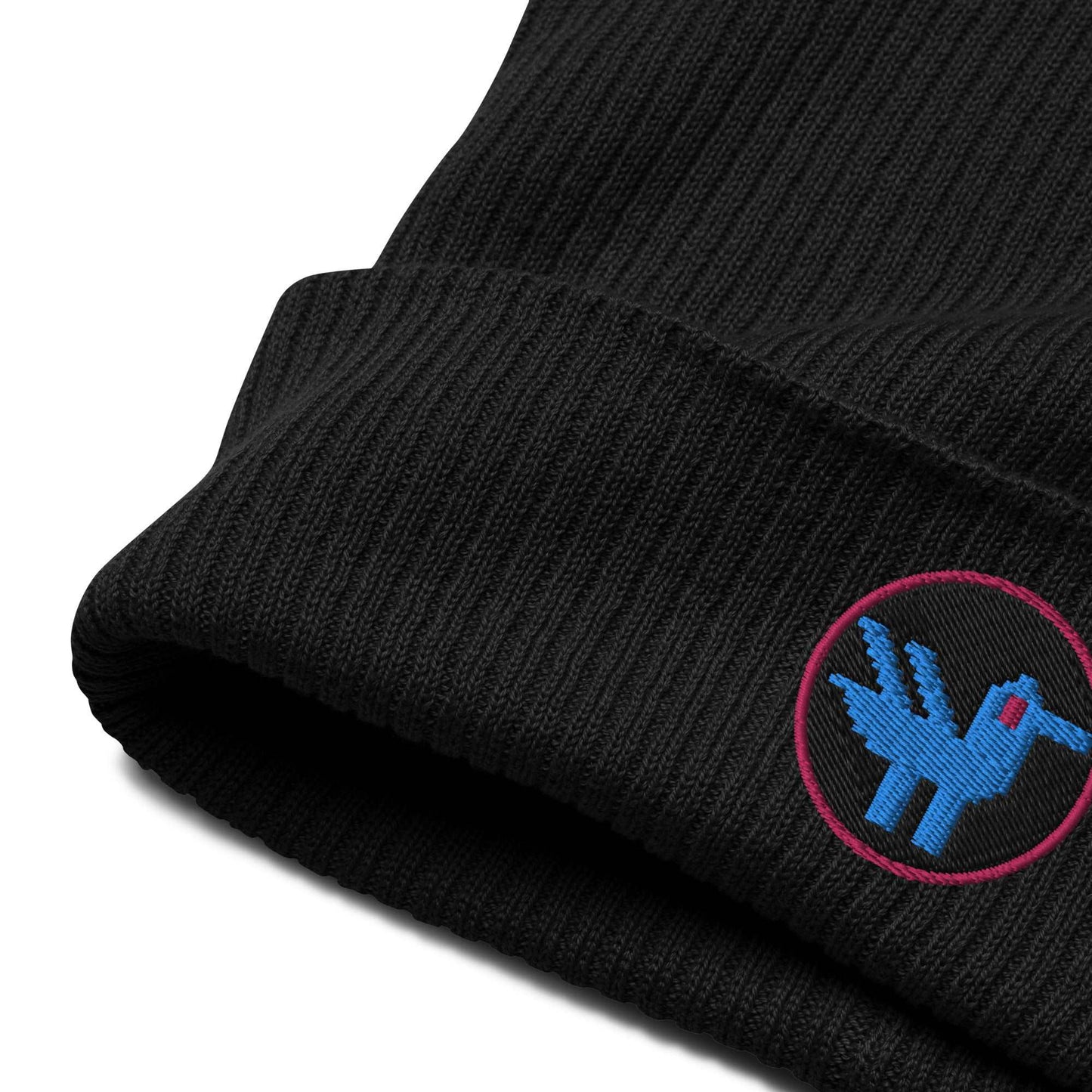 Detail of a black beanie made of 100% organic cotton with a patch embroidered on the front. The patch is a black circle with a pink border with a blue retro style duck inside.