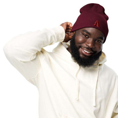 A man wearing a festive holiday burgundy ribbed beanie made of 100% organic cotton with an embroidered minimalist two-tone tree on the front.