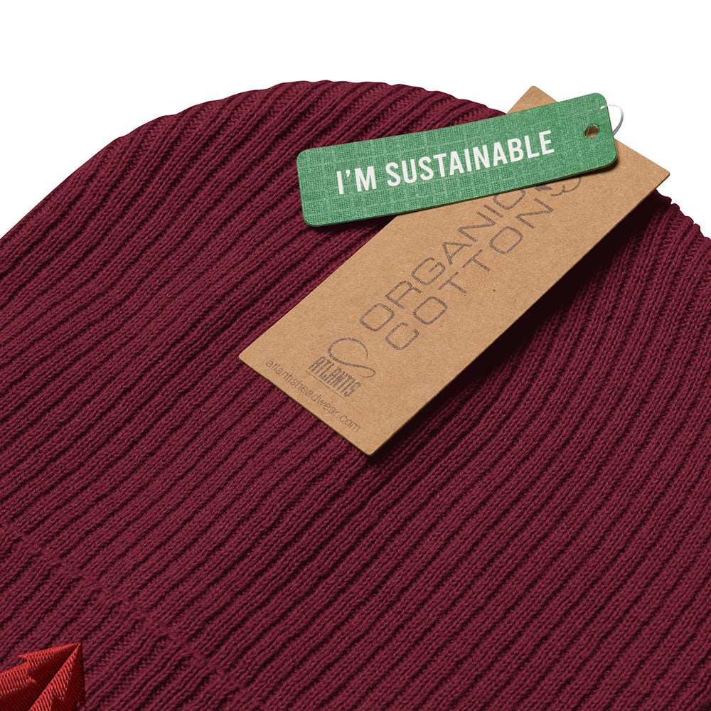 Detail of the tags on a burgundy ribbed beanie with an tree embroidered on the front. The tags say "I'm sustainable" and "Organic Cotton".