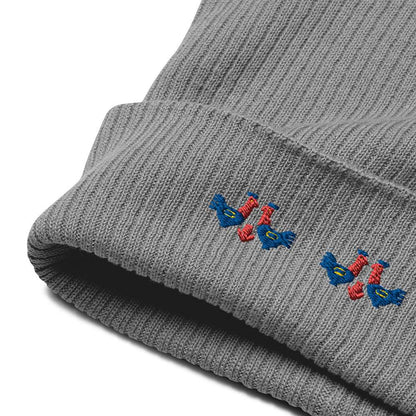 Detail of the cuff and embroidery of a 100% organic cotton light grey ribbed beanie with 3 pairs of red and blue roosters embroidered on the front.