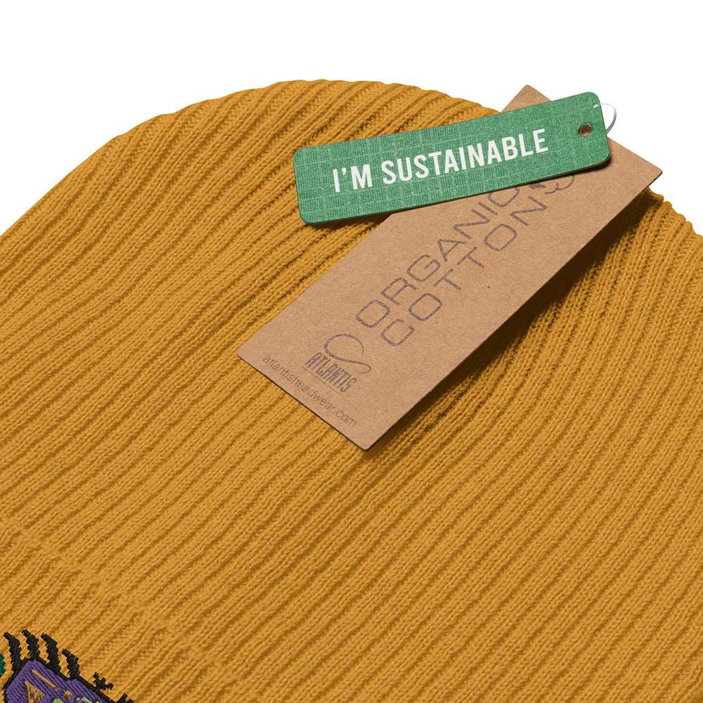 The tags of a mustard yellow ribbed beanie made of 100% organic cotton. They read "I'm Sustainable" and "Organic Cotton".