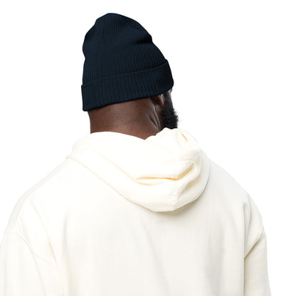 The back of a man wearing a navy blue ribbed festive holiday beanie with a gingerbread man embroidered on the front. The beanie is made of 100% organic cotton.