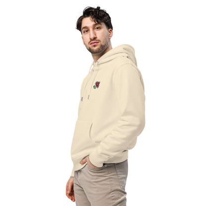 A man wearing a light tan hoodie made of organic cotton and recycled polyester with an intricate pink flower embroidered on the top left.