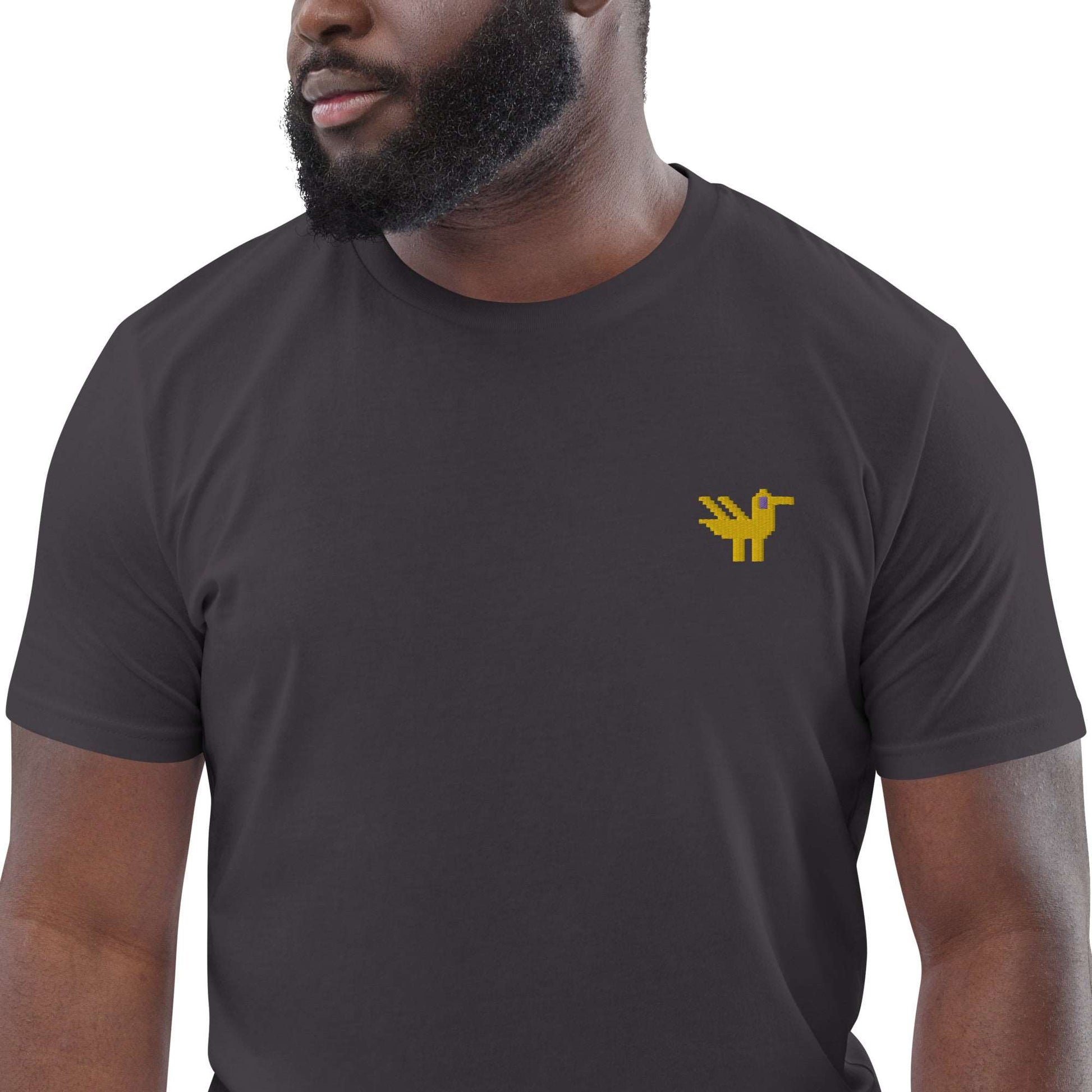 Close-up of a man wearing a dark grey t-shirt made of 100% organic cotton with a yellow duck embroidered on the top left.