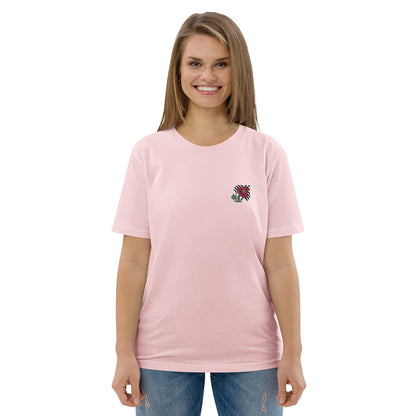 A woman wearing a light pink t-shirt made of 100% organic cotton with an intricate pink flower embroidered on the top left.