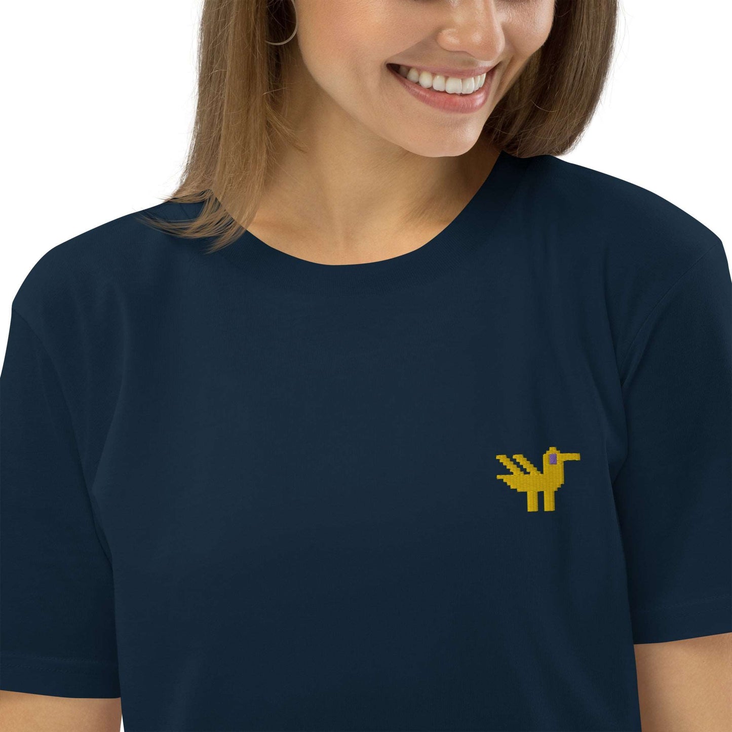 Close-up of a woman wearing a dark navy t-shirt made of 100% organic cotton with a yellow duck embroidered on the top left.