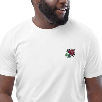 A close-up of a man wearing a white t-shirt made of 100% organic cotton with an intricate pink flower embroidered on the top left.