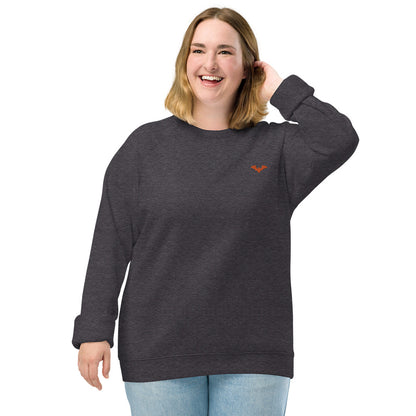 A woman wearing a spooky Halloween charcoal grey sweatshirt with a small orange bat embroidered on the top left.