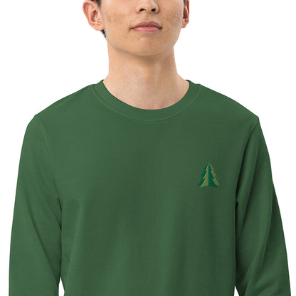 A closeup of a man wearing a festive green Christmas sweatshirt made of organic cotton and recycled polyester with a small minimalist two-tone pine tree embroidered on the top left.